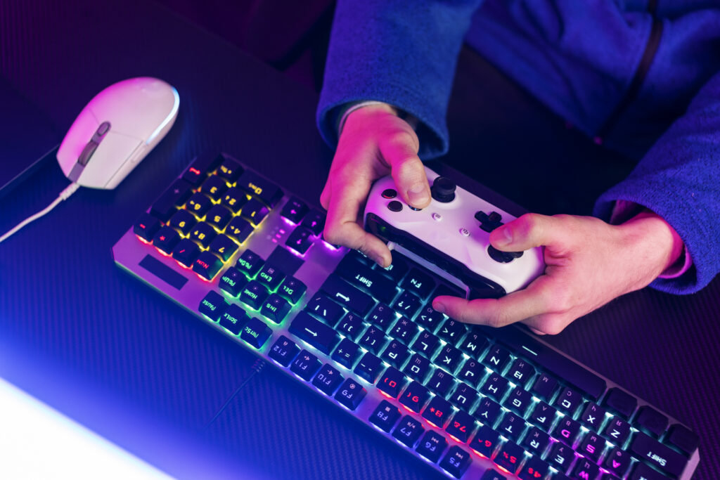 photo clavier, souris et joueur avec une manette